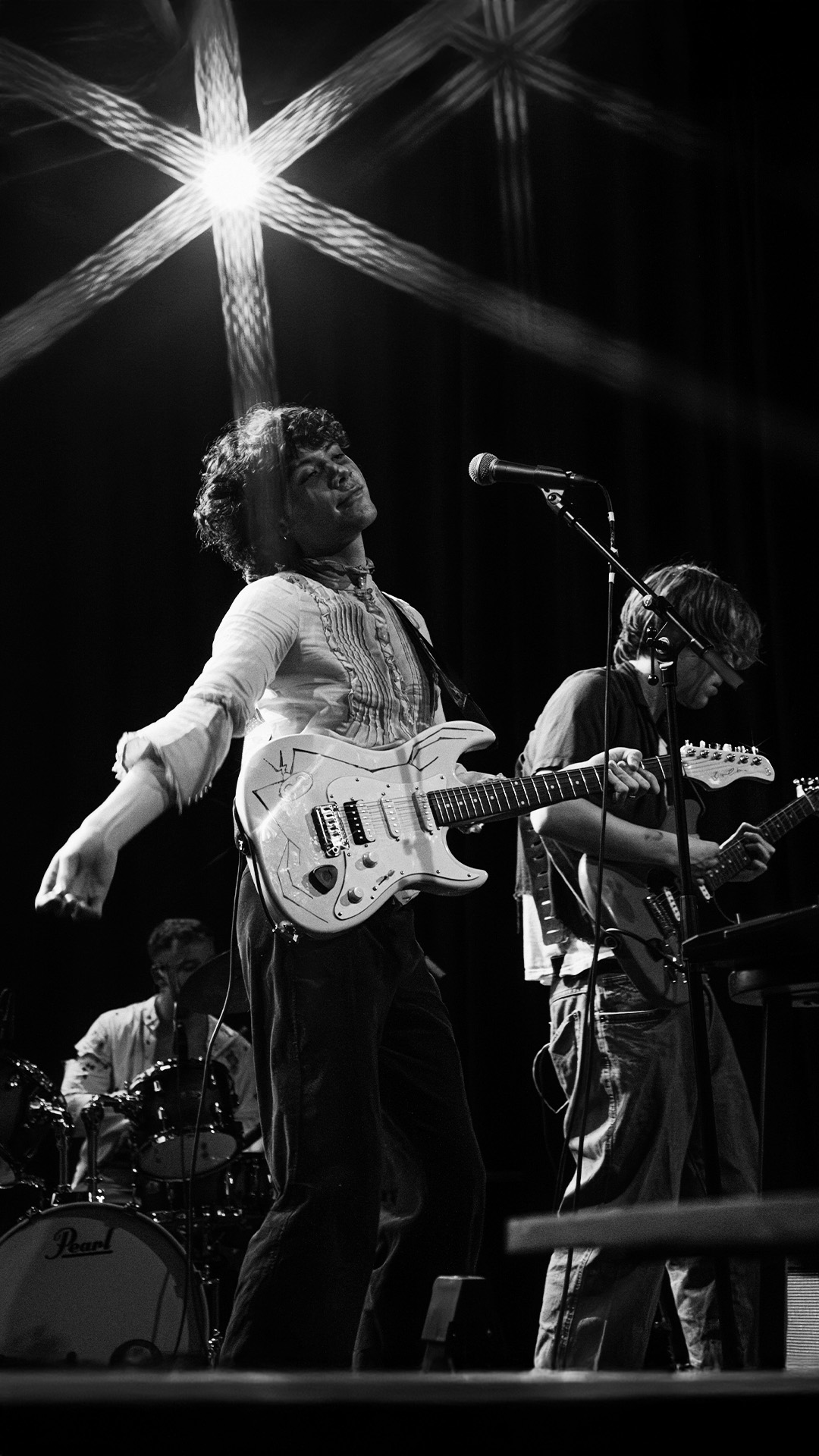 Ratchet met gitaar op het podium, naast een andere gitarist